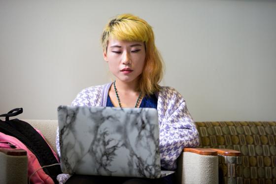 Photo of a female Chatham University student working on her laptop